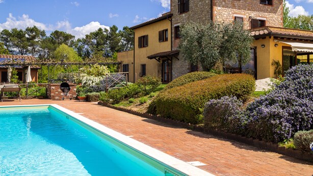 A two-story house with a swimming pool, surrounded by well-maintained gardens and trees. - Villa ' Pian del Rocchio ' - Beautiful Country House in a lush Umbria plateau (San Venanzo (TR))