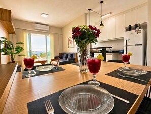 A modern kitchen with a dining area, a large window, and a view of the outdoors.