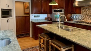 A kitchen with wooden cabinets, a stainless steel sink, a built-in oven, and a granite countertop. - HISTORIC LAKE PLACID WATERFRONT GREAT CAMP-6 BR- Each w/private full bath. (Lake Placid)