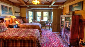 A room with two beds, a ceiling fan, a wooden cabinet, and a large window. - HISTORIC LAKE PLACID WATERFRONT GREAT CAMP-6 BR- Each w/private full bath. (Lake Placid)