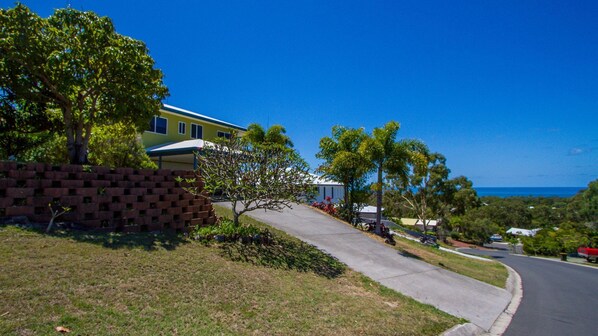 A residential street with houses, a clear blue sky, and a view of the ocean. - SEABRIGHT holiday house (AGNES WATER)