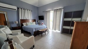 Une chambre à coucher comprenant un lit, un bureau, une chaise, un téléviseur et une armoire.