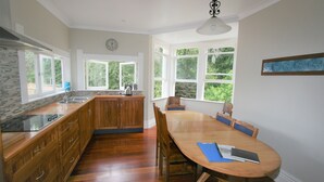 A kitchen with wooden cabinets, a large island, and a dining area with a table and chairs.