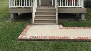 A small, single-story building with a porch, a front door, and a mailbox. - Peaceful, Private Cottage On Bayou Teche (New Iberia)