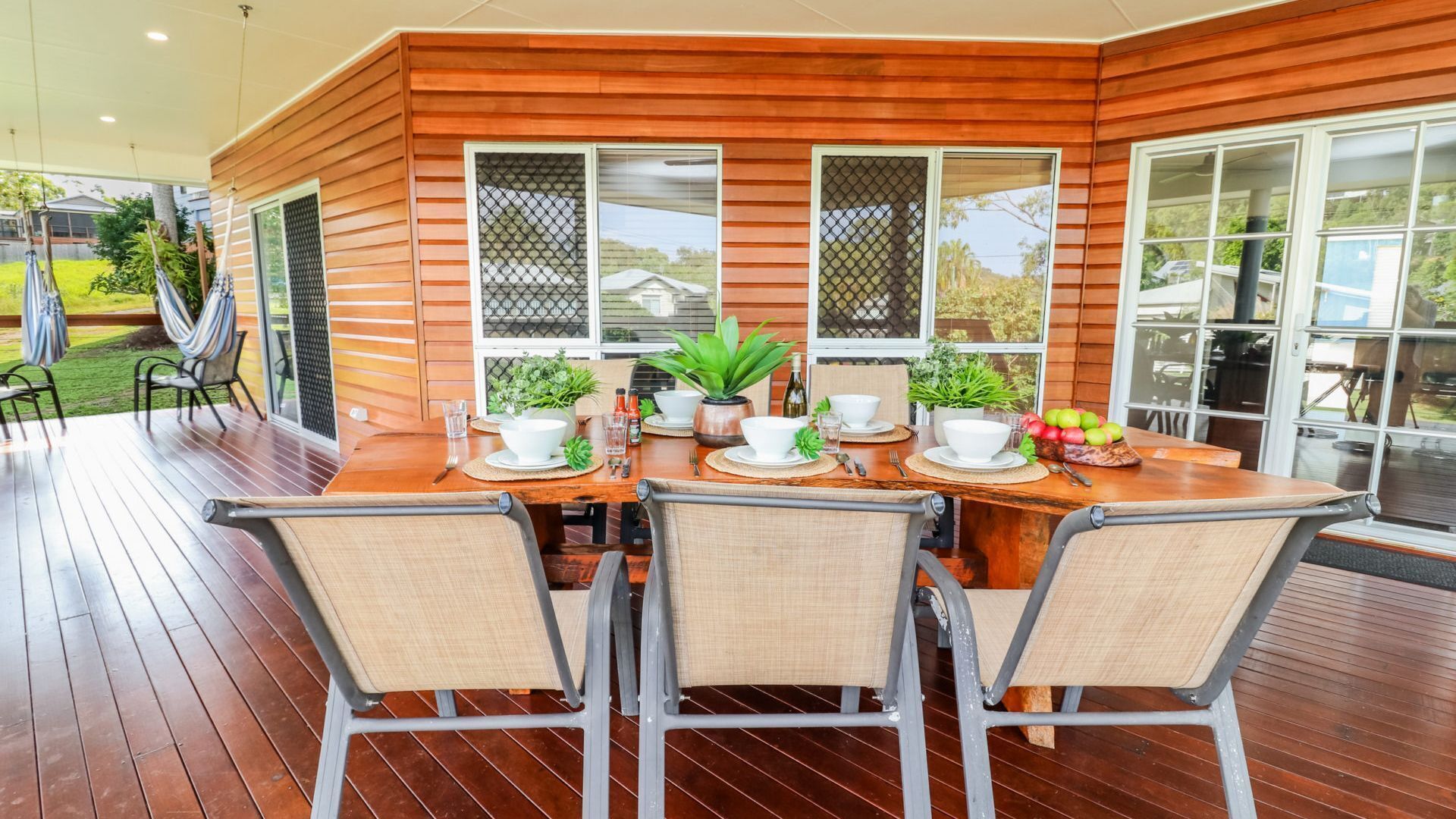 Un coin repas avec une table en bois, quatre chaises et une vue sur l’extérieur.