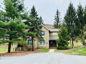 A two-story building with a front entrance, a visible mailbox, and a driveway leading to the entrance.