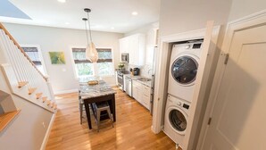 Une cuisine moderne dotée d’un îlot en marbre, d’appareils électroménagers intégrés et d’un lave-linge.