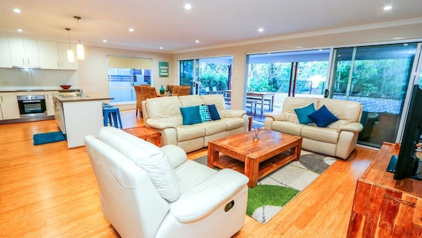 A modern living room with a sofa set, a coffee table, and a TV.