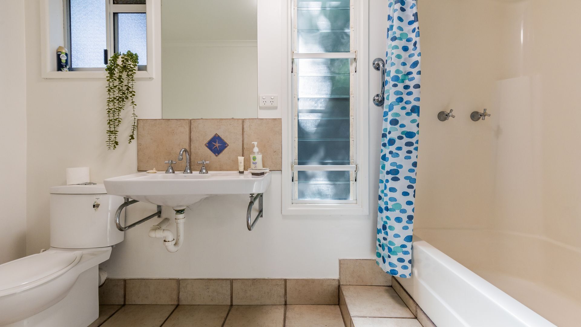 A bathroom with a toilet, sink, and shower.