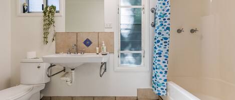 A bathroom with a toilet, sink, and shower.
