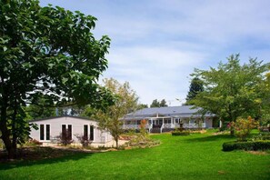 Relax on the covered porch amidst mature trees and a well-manicured lawn.