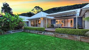 Una casa moderna con césped cuidado y un patio.