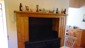 Una habitación con chimenea, un armario de madera y una silla.