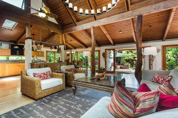 A spacious living area with wicker furniture, a fireplace, and a view of the outdoors. - THANKSGIVING Avail. Resort-like, 200 m to Lanikai Beach, Private Pool, AC, WiFi (Kailua)
