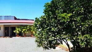 A building with a red roof and a gravel driveway. - Hotel Amaranto (San Juan)