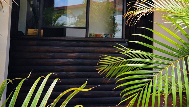A modern building with a wooden staircase leading to a glass door. - Hotel Amaranto (San Juan)