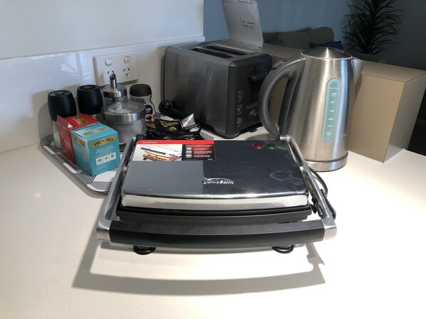 A compact kitchen setup with a toaster, kettle, and Twinings coffee boxes. - Northshore apartment, separate entry, stroll to beach, quiet location. (Kallaroo)