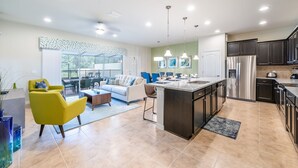 A modern kitchen with a central island, dark cabinetry, and stainless steel appliances. - Brand new villa in amazing resort (Kissimmee)