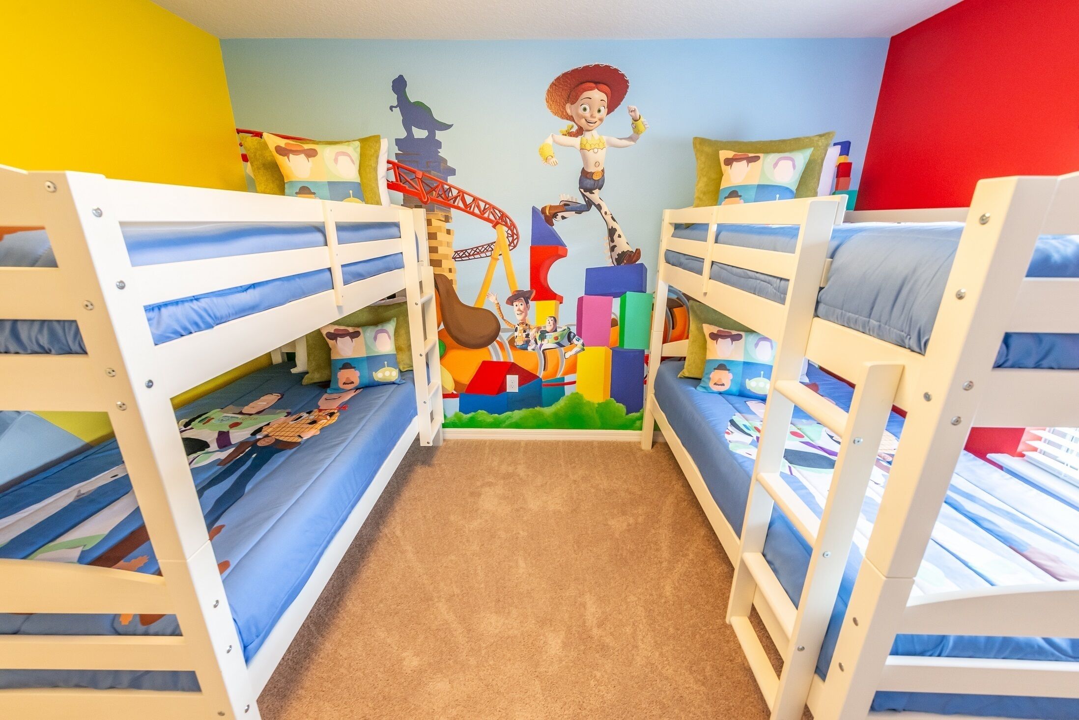 Una habitación infantil con literas, decoraciones de pared coloridas y suelo alfombrado.