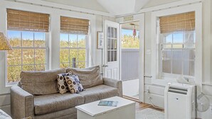 A room with a sofa, a coffee table, and a window with a view of the beach. - Oceanside 1 -  East Sandwich waterfront cottage (Sandwich/East Sandwich)