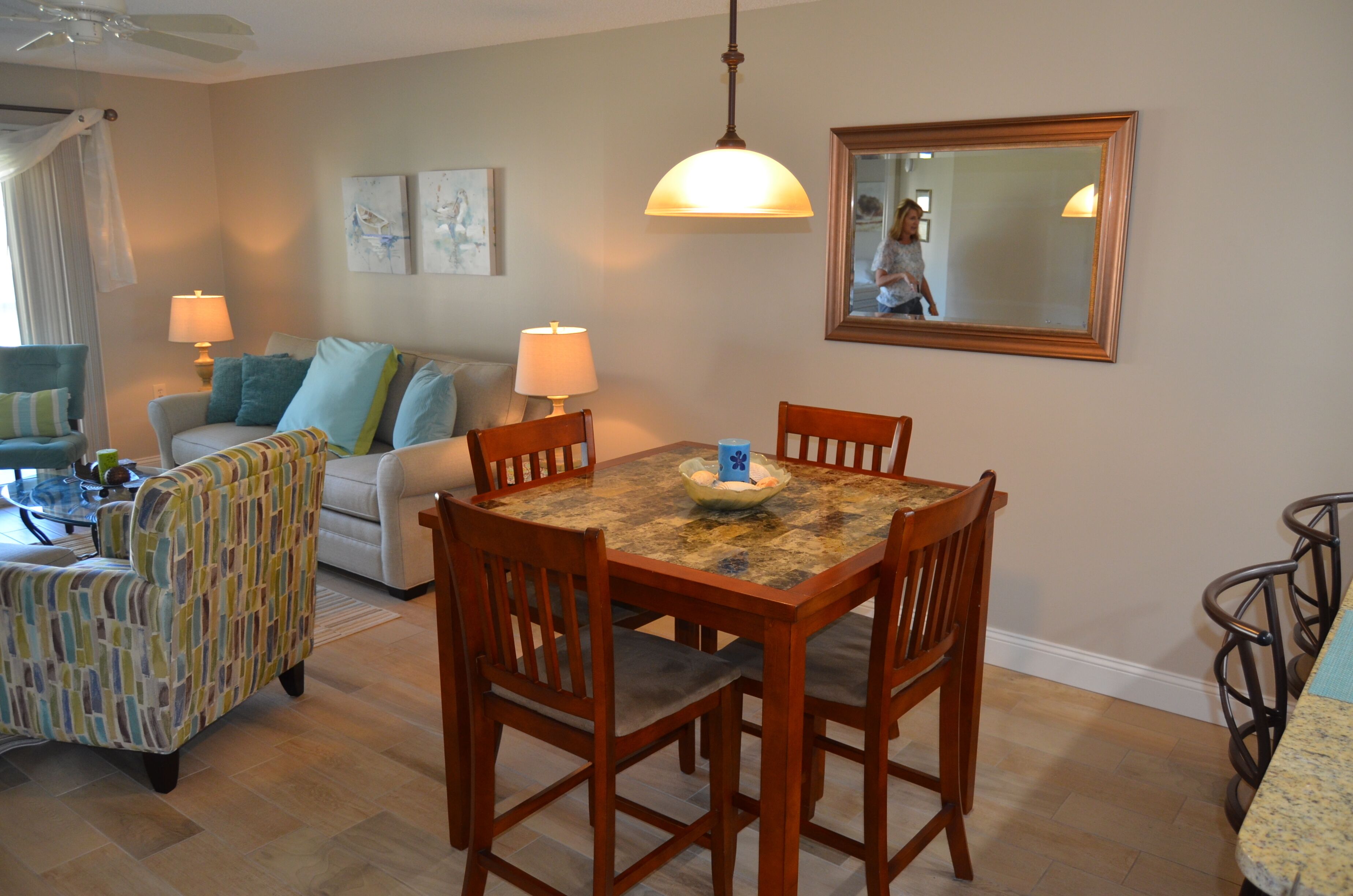 A dining area with a wooden table and chairs, a sofa, and a patterned armchair.