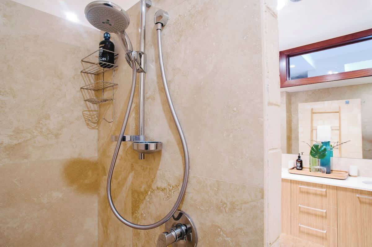 A bathroom with a shower, a towel rack, and a mirror.