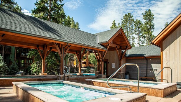 Un'area benessere con vasche idromassaggio e un pontile in legno.
