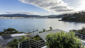 Vista sobre un llac amb un moll, un petit pont i una ciutat a la distància.