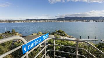 A sign for Harbour Studio with a view of a coastal city and water.