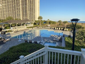 A pool area with lounge chairs, a gazebo, and a view of the ocean. - 2BR/2BA ResortCondo, Beach/Shopping/Entertainment, Free WiFi & Parking, Clean (Myrtle Beach)
