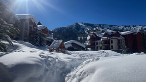 Une ville de montagne enneigée, avec des bâtiments et un ciel bleu dégagé.