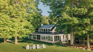 Een modern huis met een overdekte patio, omringd door bomen.