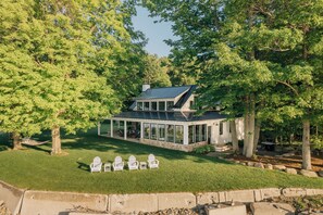 A modern house with a covered patio, surrounded by trees. - Lake Erie Lakefront Custom Built Cottage ~ Amazing Sunsets ~ Private!   (North East)