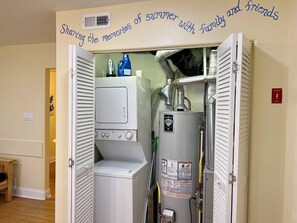 Ein kleiner Hauswirtschaftsraum mit Waschmaschine, Trockner und Warmwasserbereiter.