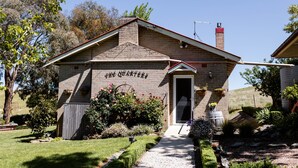 Un bâtiment en briques avec un toit rouge et une cheminée, portant l’inscription « The Quarters ».