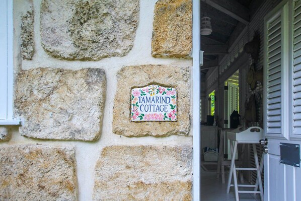 A stone wall with a sign reading "Tamarind Cottage."