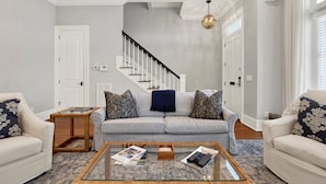 A living room with a sofa set, a coffee table, and a staircase. - Heated Pool Access | 5*Clean | Flex Cancelation (Savannah)