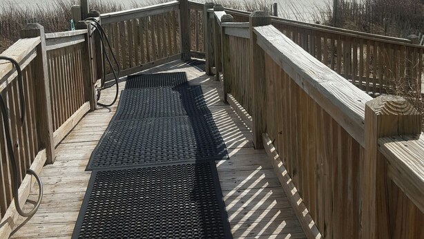 A wooden boardwalk leading to a beach with a clear sky. - Family-Friendly Oceanfront Condo That Has A Pool, Lazy River, And Jacuzzi. (North Myrtle Beach)