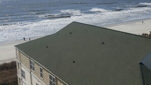 A building with a flat roof overlooking a beach. - Family-Friendly Oceanfront Condo That Has A Pool, Lazy River, And Jacuzzi. (North Myrtle Beach)