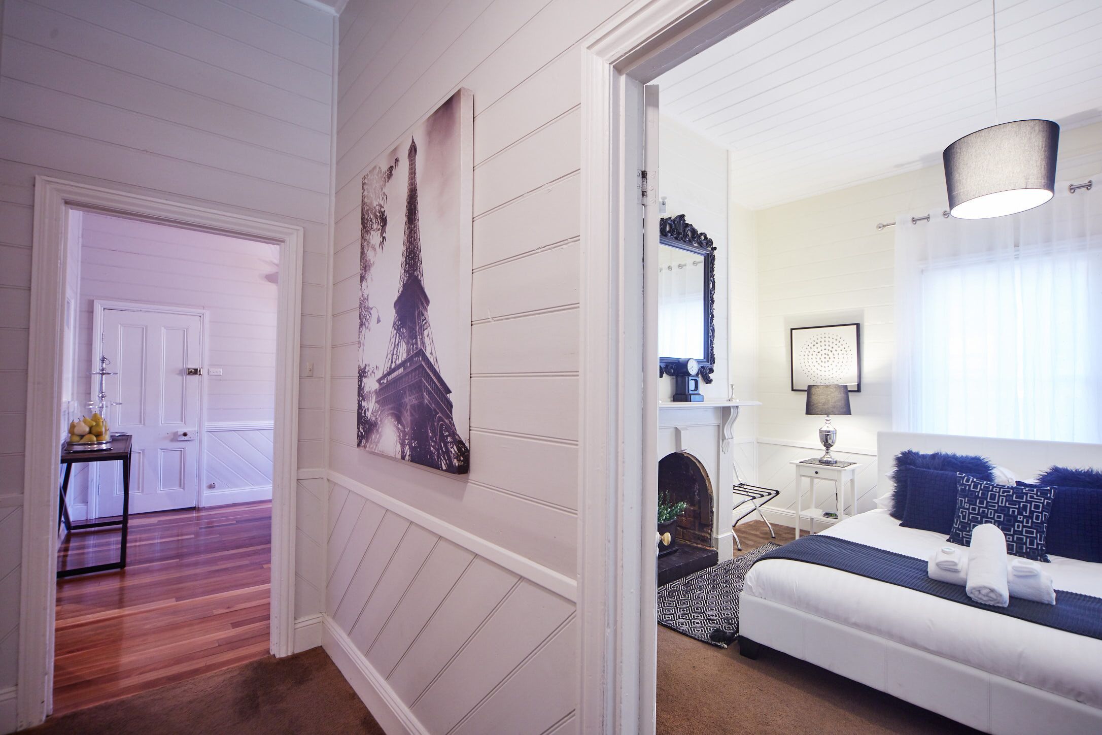 A bedroom with a bed, a nightstand, a lamp, and a window with curtains.