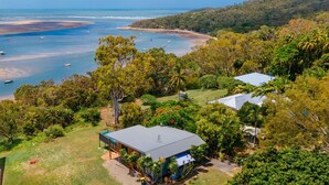 An aerial view of a coastal property with a large house, a swimming pool, and a beach area with boats. - SPEEDYS SHACK   1770 - panoramic ocean & bay views (SEVENTEEN SEVENTY)