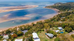An aerial view of a coastal area with a beach, boats, and residential buildings. - SPEEDYS SHACK   1770 - panoramic ocean & bay views (SEVENTEEN SEVENTY)
