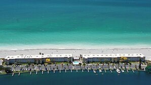 An aerial view of a hotel with a marina, beach, and ocean. - BEACHFRONT CONDO - THREE BEDROOM - HEATED POOL - FREE BOAT DOCKS - RENOVATED (Sarasota)