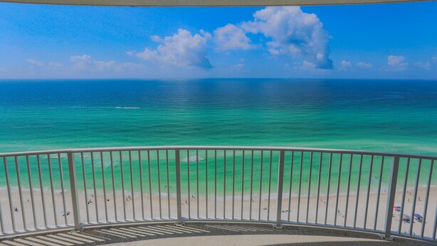 Un balcon avec vue sur une plage et l’océan.