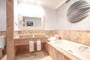 Ein modernes Badezimmer mit zwei Waschbecken, einer großzügigen Badewanne und einem Wanddekor.