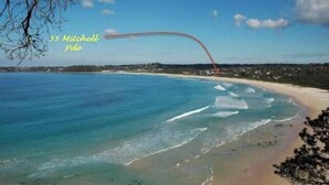A coastal view with clear blue waters, a sandy beach, and a red curved structure. - A stone's throw from Mollymook Beach (Mollymook)