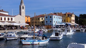 A marina with boats docked, a clock tower, and colorful buildings. - Holiday apartment in village Valbandon, 1km from the beach (Valbandon, Fažana)