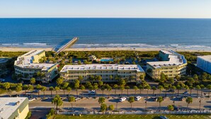 Ein Hotel an der Küste mit Blick auf den Strand, Parkplatz und einem Steg.