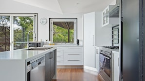 A modern kitchen with a dishwasher, stove, and sink.