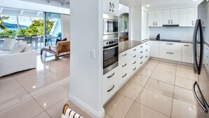 Una cocina moderna con armarios blancos, electrodomésticos de acero inoxidable y una isla grande.